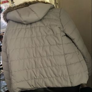 Woman’s tan jacket with removable hood with fur on outside of hood zipper vest
